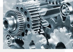 Close-up of an interlocking arrangement of metallic gears and cogs, showcasing their teeth and detailed structure. The image highlights the precision engineering of the mechanical components.