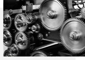 Close-up view of an intricate arrangement of variously sized metal gears and cogs in a mechanical system, showcasing the complexity and precision of the engineering involved.